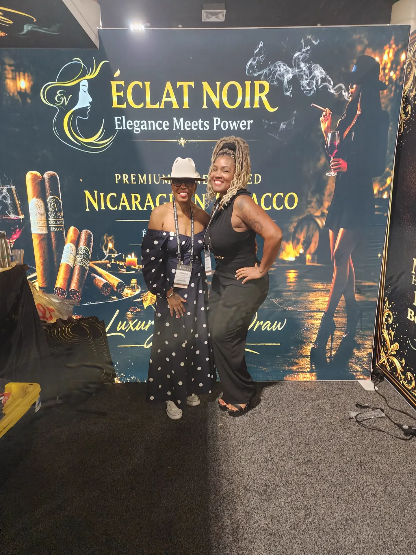 Founder and CEO L. Howard with a guest in front of the ÉCLAT NOIR booth display of cigars, PCA Trade Show, New Orleans, April 2026.