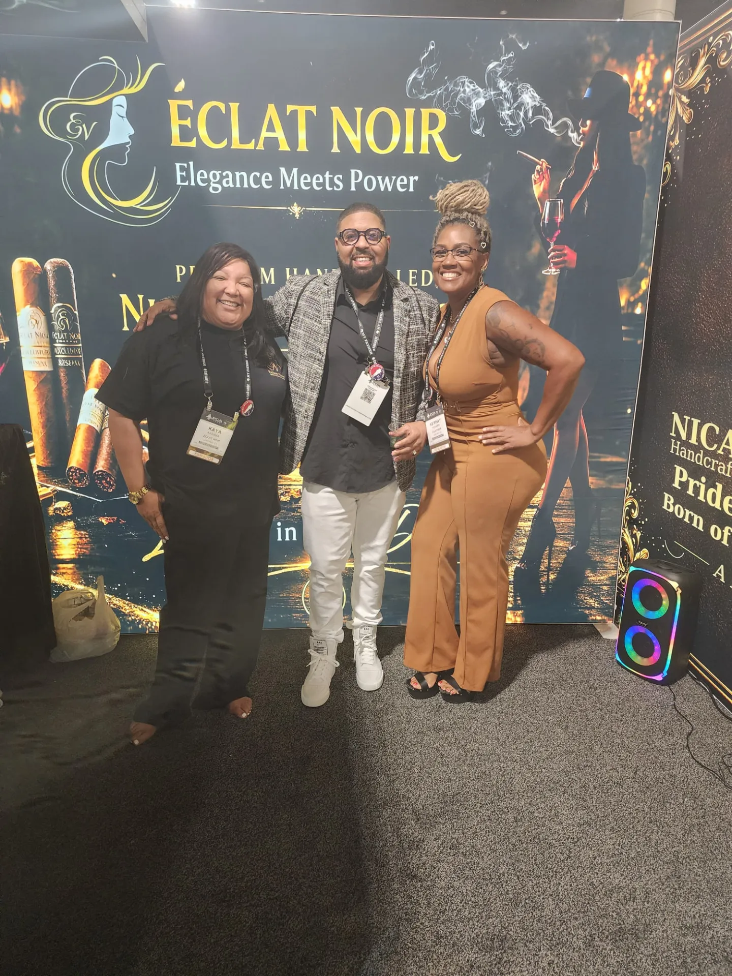 Founder and CEO L. Howard with two attendees in front of the ÉCLAT NOIR booth at the PCA Trade Show, New Orleans, April 2026.