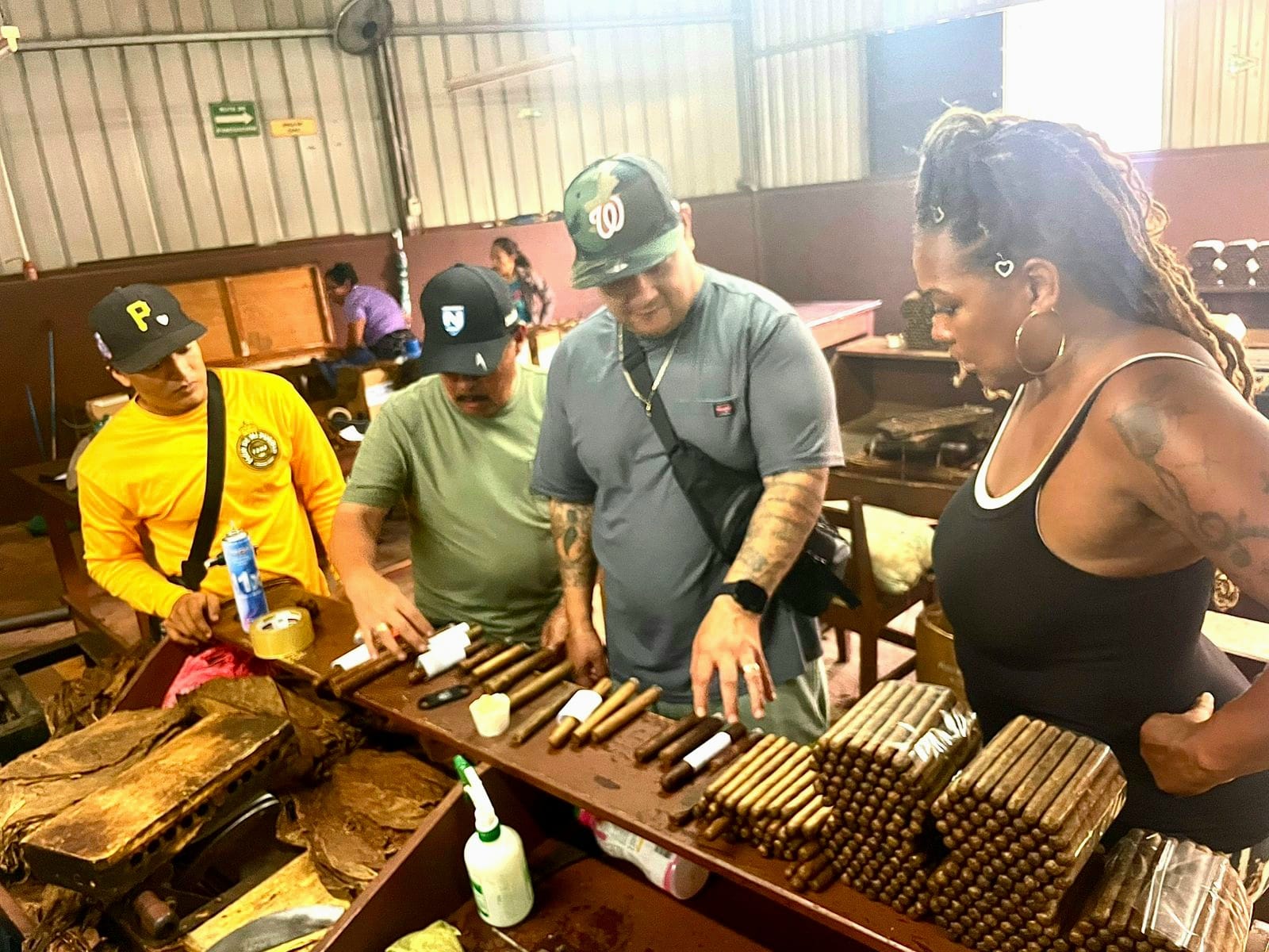 Founder L. Howard reviewing finished cigars with three Nicaraguan makers over a bench of banded and unbanded stock.