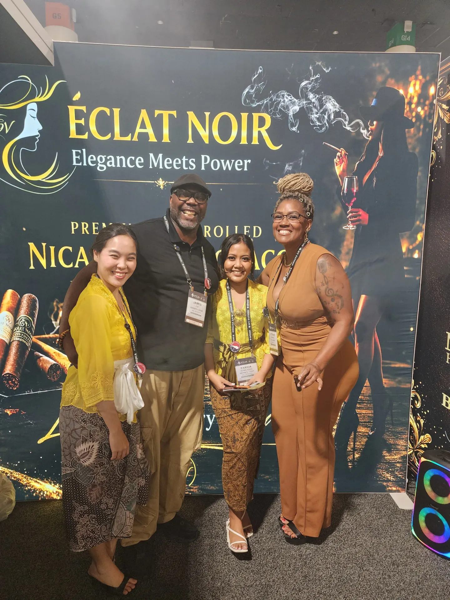 Founder and CEO L. Howard with three international attendees in front of the ÉCLAT NOIR banner, PCA Trade Show, New Orleans, April 2026.