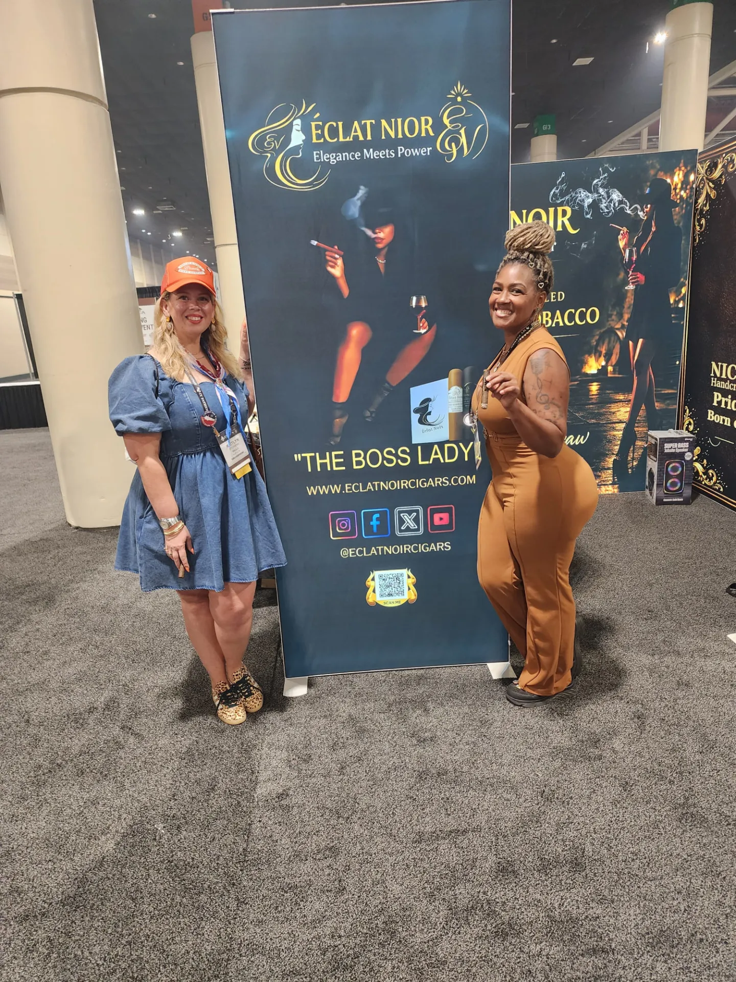Founder and CEO L. Howard holding ÉCLAT NOIR cigars beside The Boss Lady booth banner at the PCA Trade Show, New Orleans, April 2026.